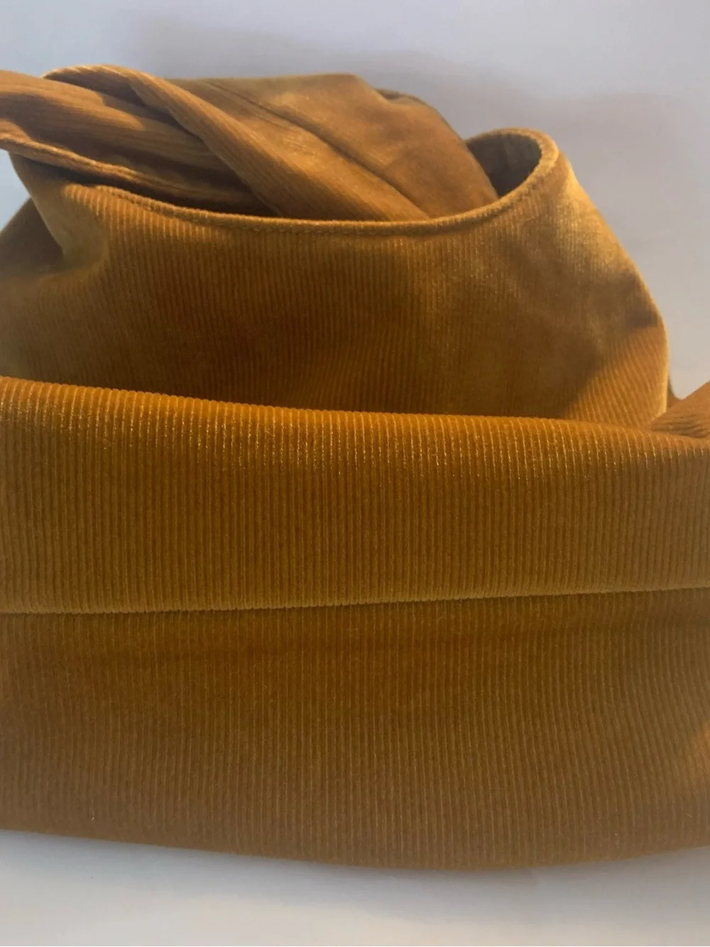 Merit Beauty Signature Bag in a golden brown or camel corduroy material